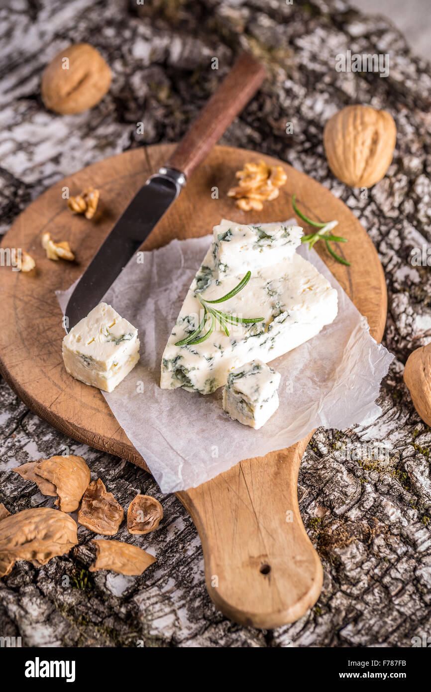Delizioso formaggio con stampo sul tagliere di legno Foto Stock