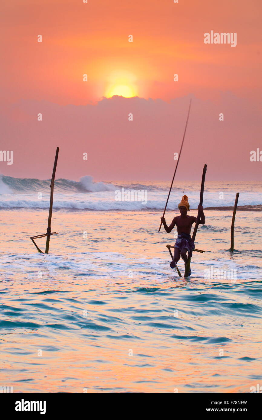 Stilt locale pescatore al tramonto, Koggala Beach, Sri Lanka, Asia Foto Stock