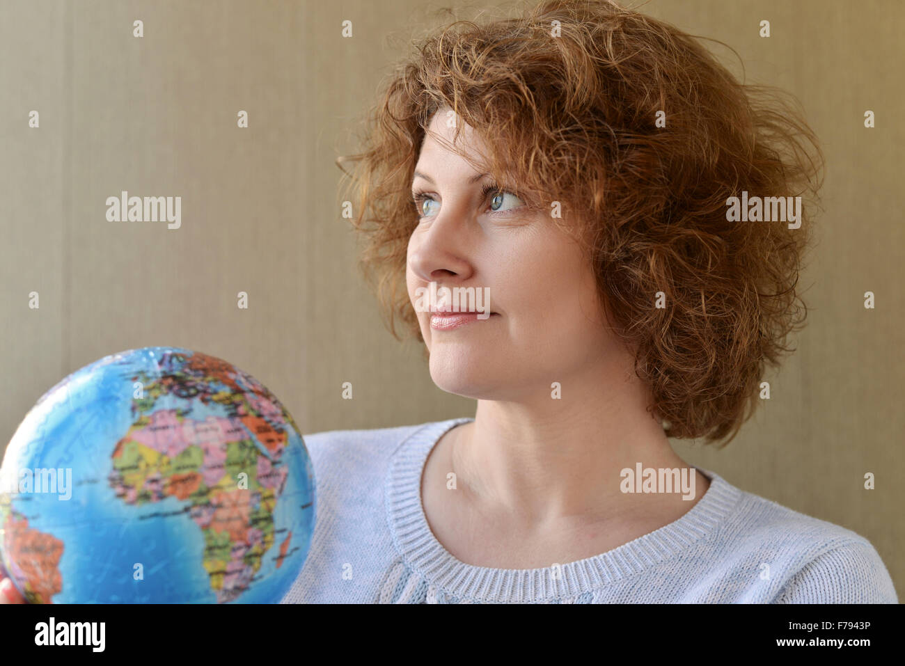 Donna con globo in mani pensando di viaggiare Foto Stock