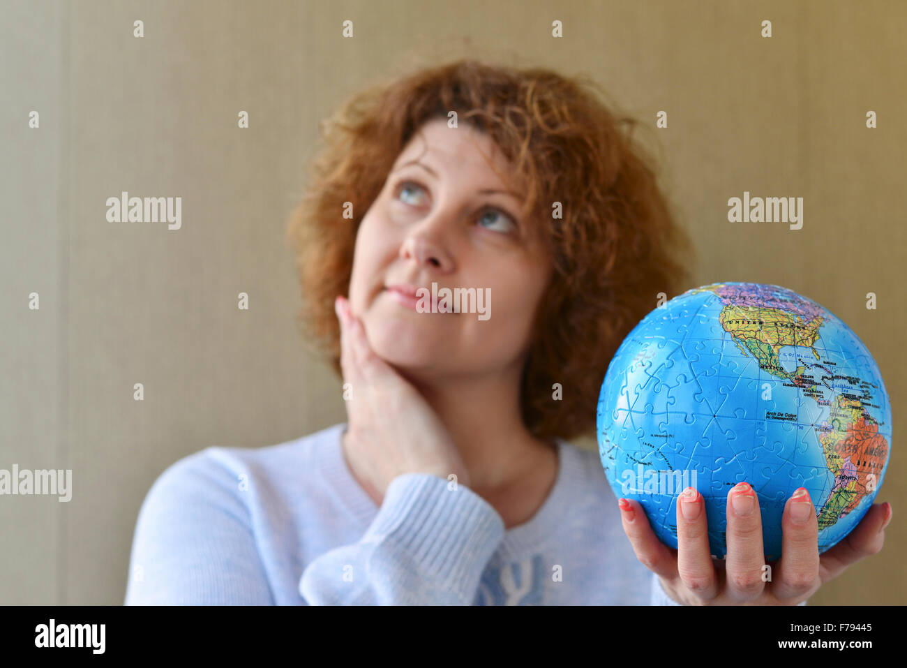 Donna con globo in mani pensando di viaggiare Foto Stock