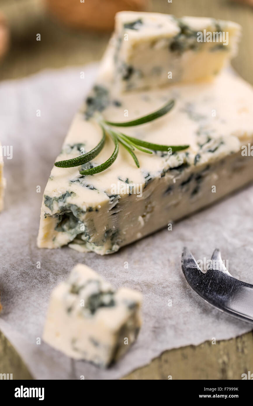 Gustoso formaggio blu con noci su carta sgualcita Foto Stock