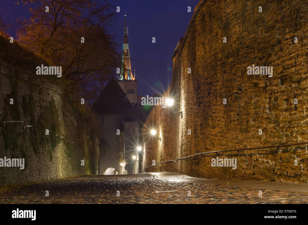 Che conducono giù Pikk Jalg street illuminata di notte con vista sulla chiesa di Oleviste, Tallinn, Estonia Foto Stock