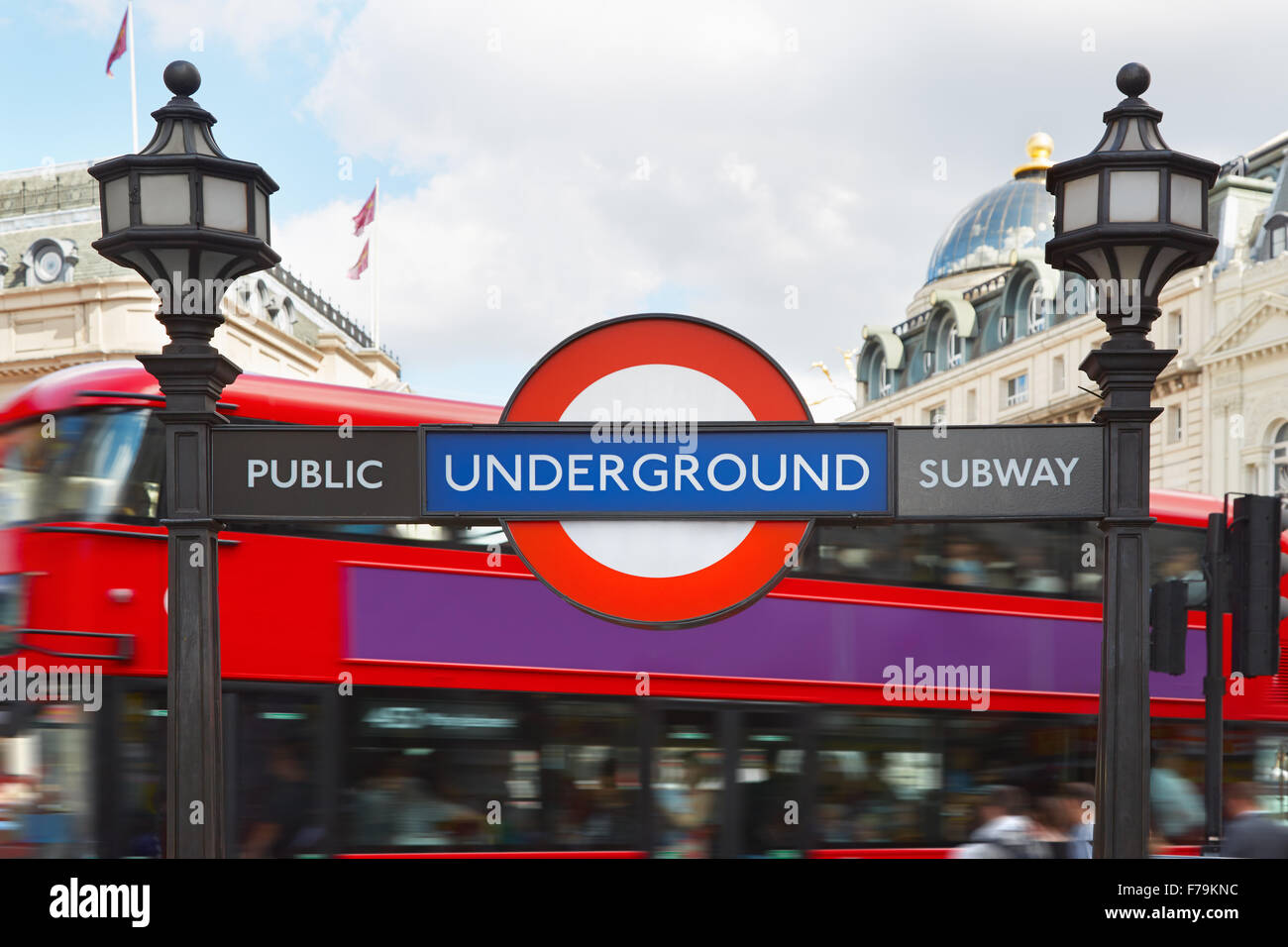 La metropolitana di Londra segno con lampade stradali e bus rosso a due piani sullo sfondo Foto Stock