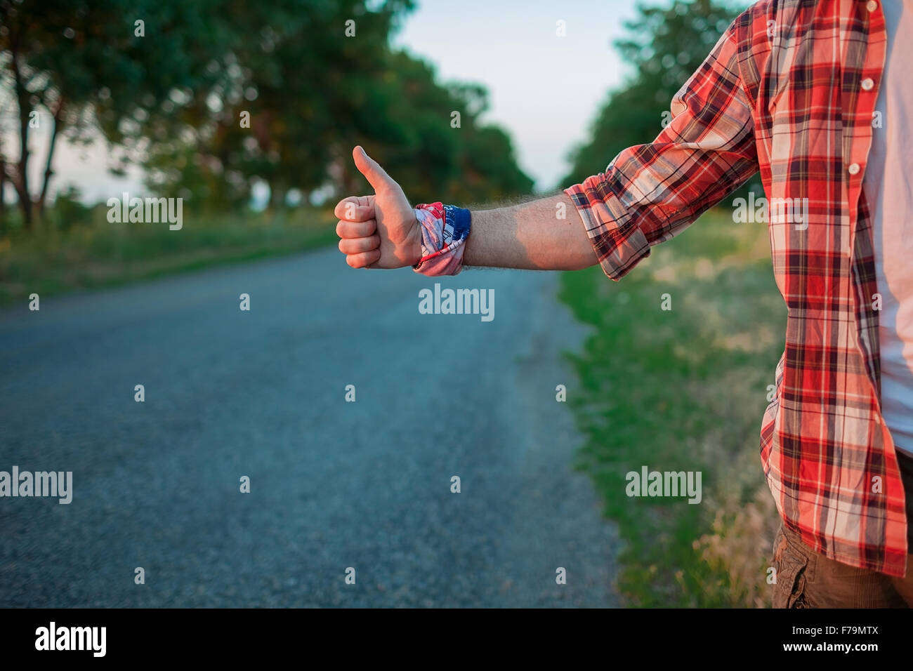 Giovani caucasici autostop turistico lungo una strada. Foto Stock