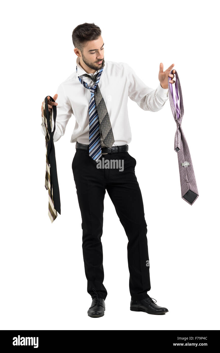 Uomo di vestirsi scegliendo tra molti cravatte. Corpo pieno lunghezza ritratto isolato su bianco di sfondo per studio Foto Stock