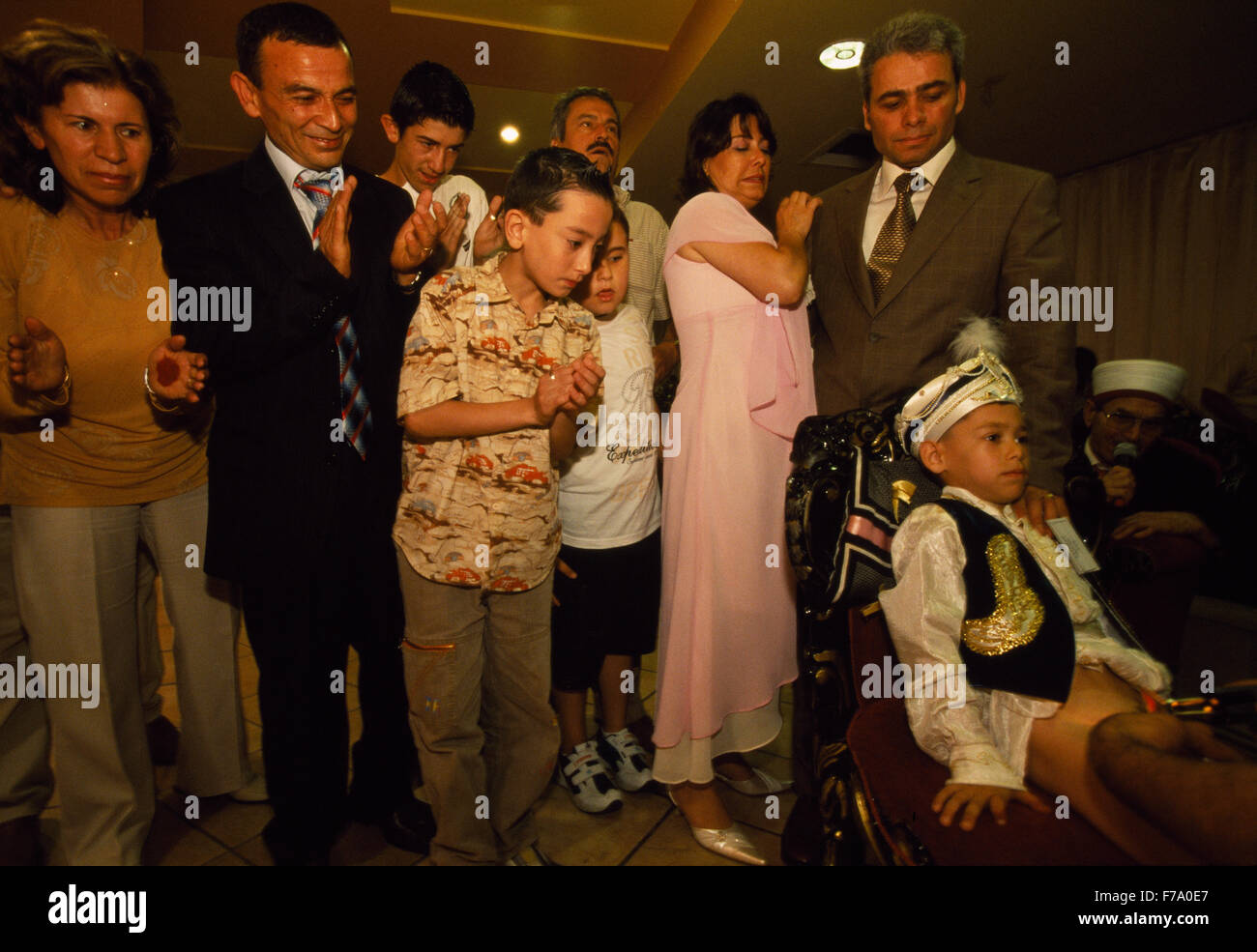 Un ragazzo è stato circonciso a Kemal Özkan circoncisione del Palace a Istanbul, Turchia. La sua famiglia si sono riuniti dietro di lui nel supporto. Foto Stock