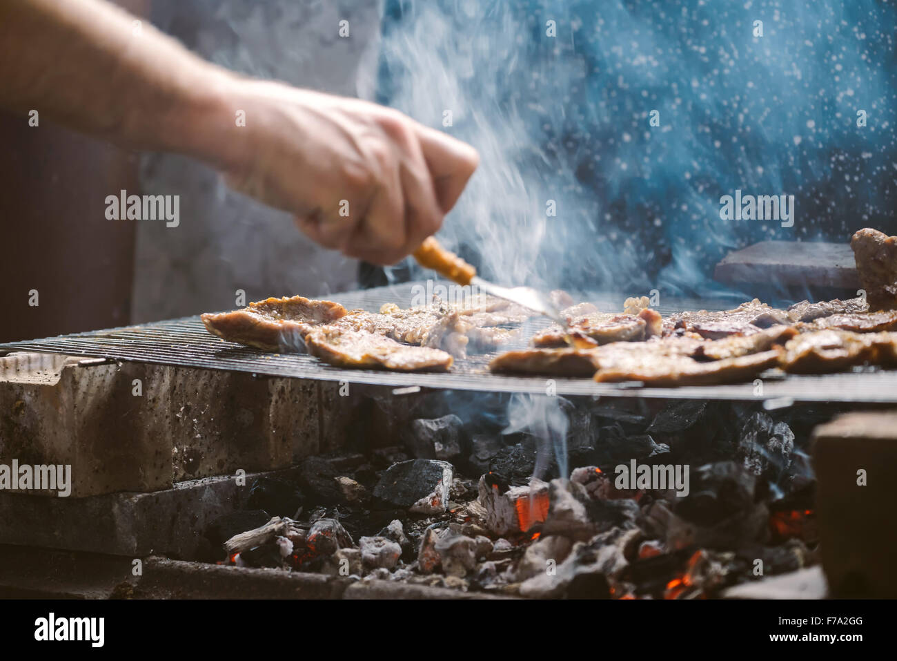 Per grigliare carne di maiale braciole sul barbecue, messa a fuoco selettiva con profondità di campo ridotta. Foto Stock