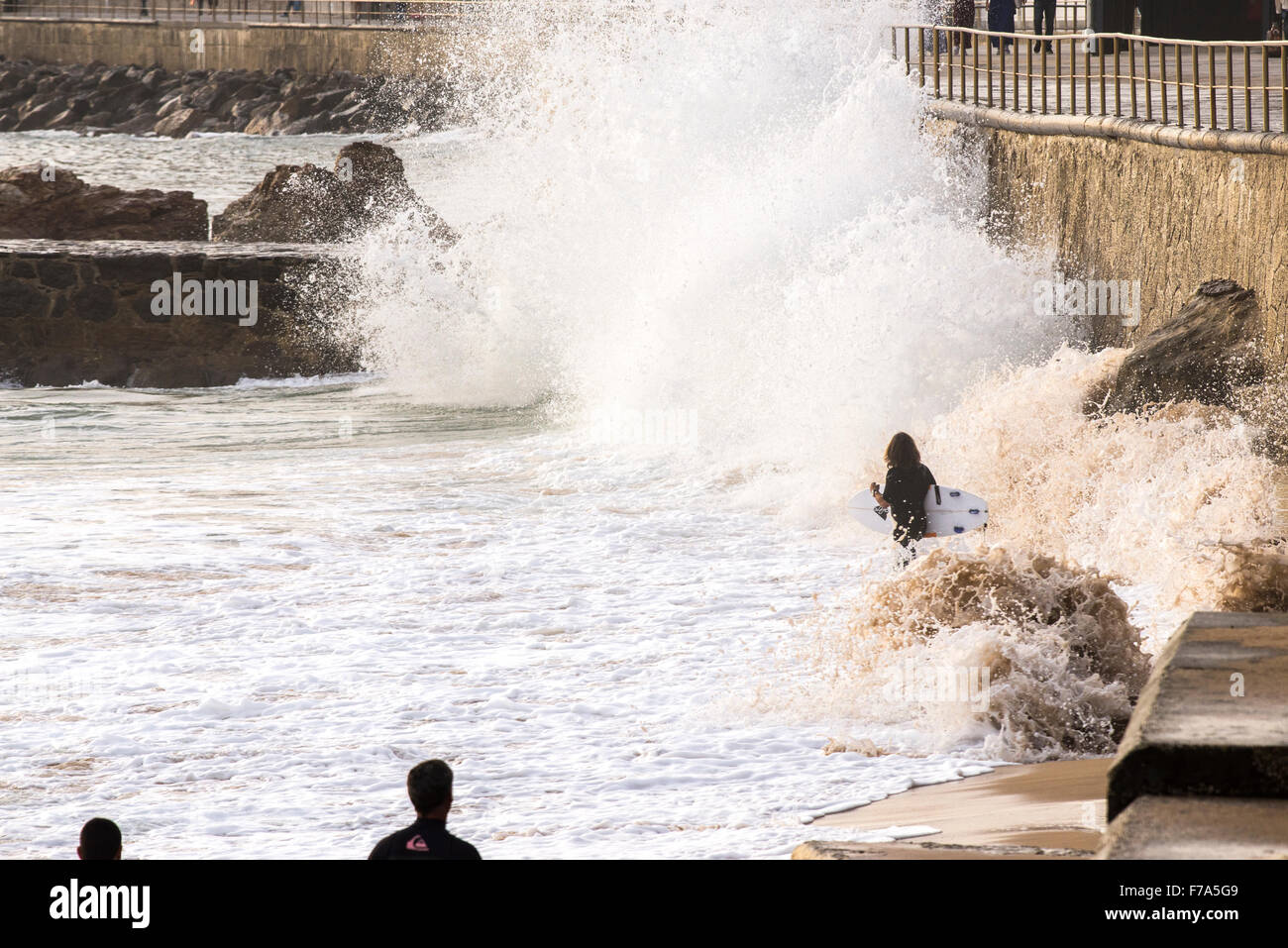 3 surfers camminando lungo il suono con le onde del mare, Cascais, Portogallo Foto Stock