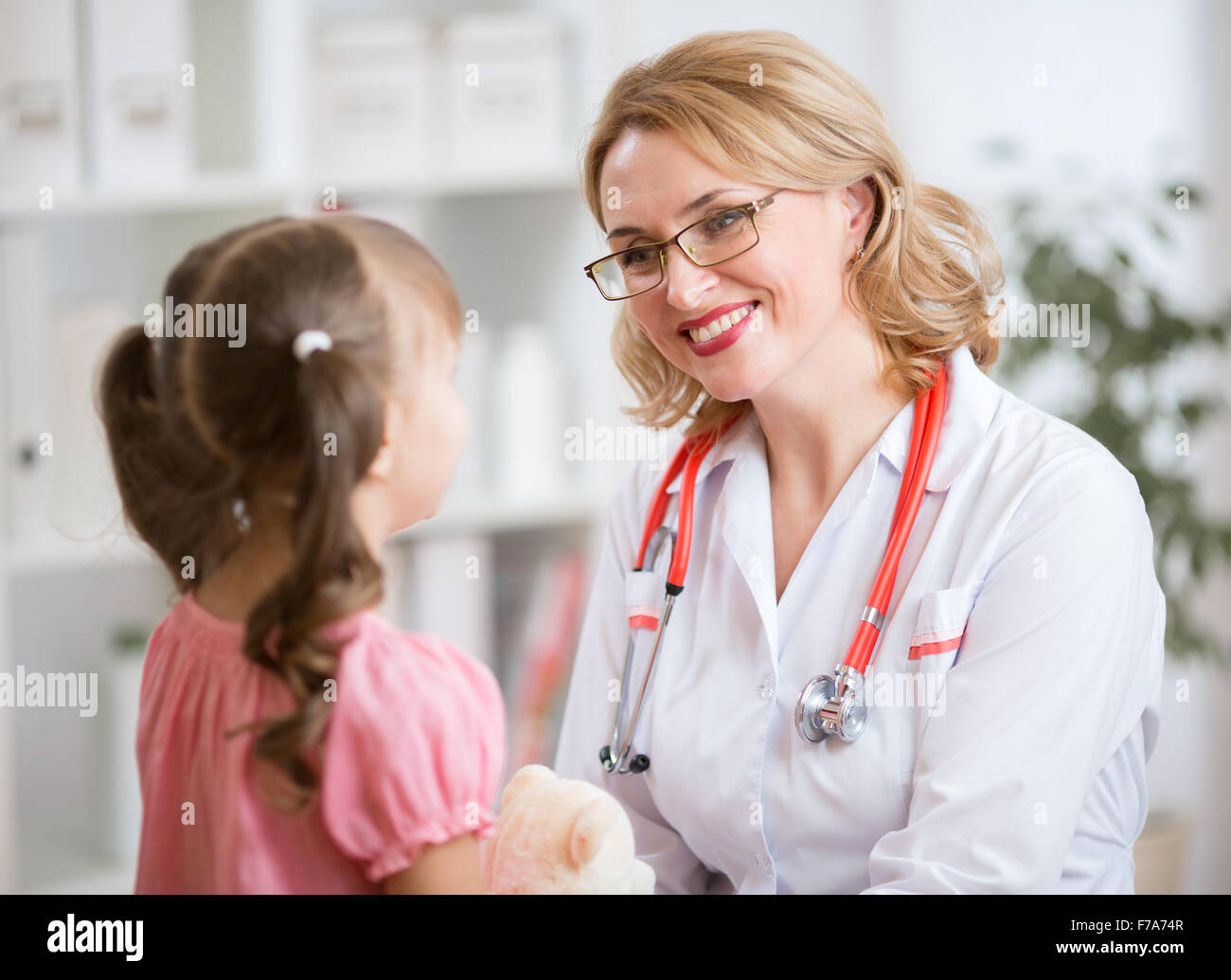 Medico pediatra esaminando kid Foto Stock