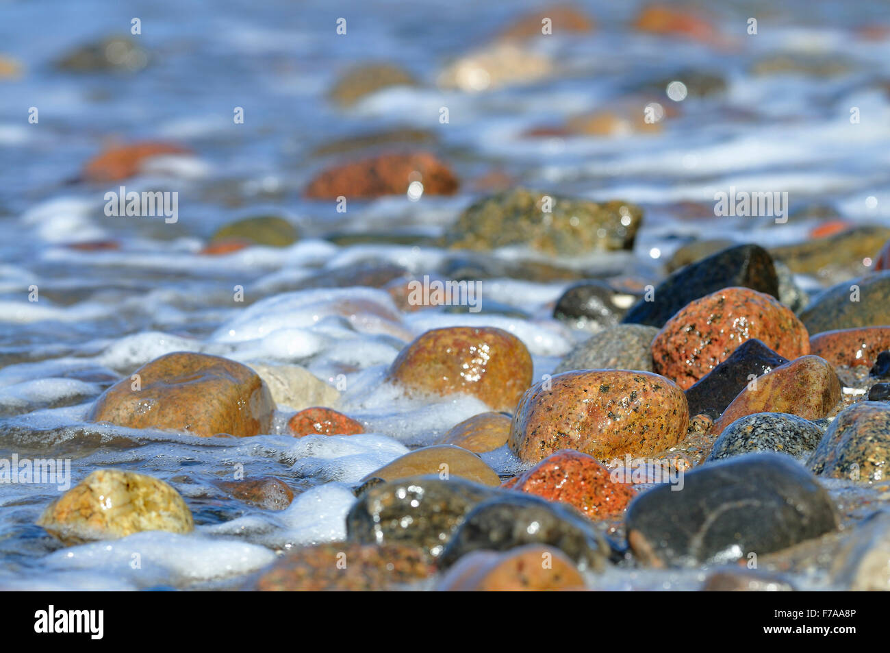 Le pietre colorate con gli spruzzi di acqua, Hohes Ufer vicino Ahrenshoop, Fischland-Darß-Zingst, Meclenburgo-Pomerania Occidentale, Germania Foto Stock