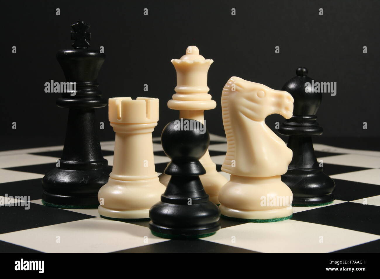 Pezzi di scacchi a bordo con sfondo nero Foto Stock