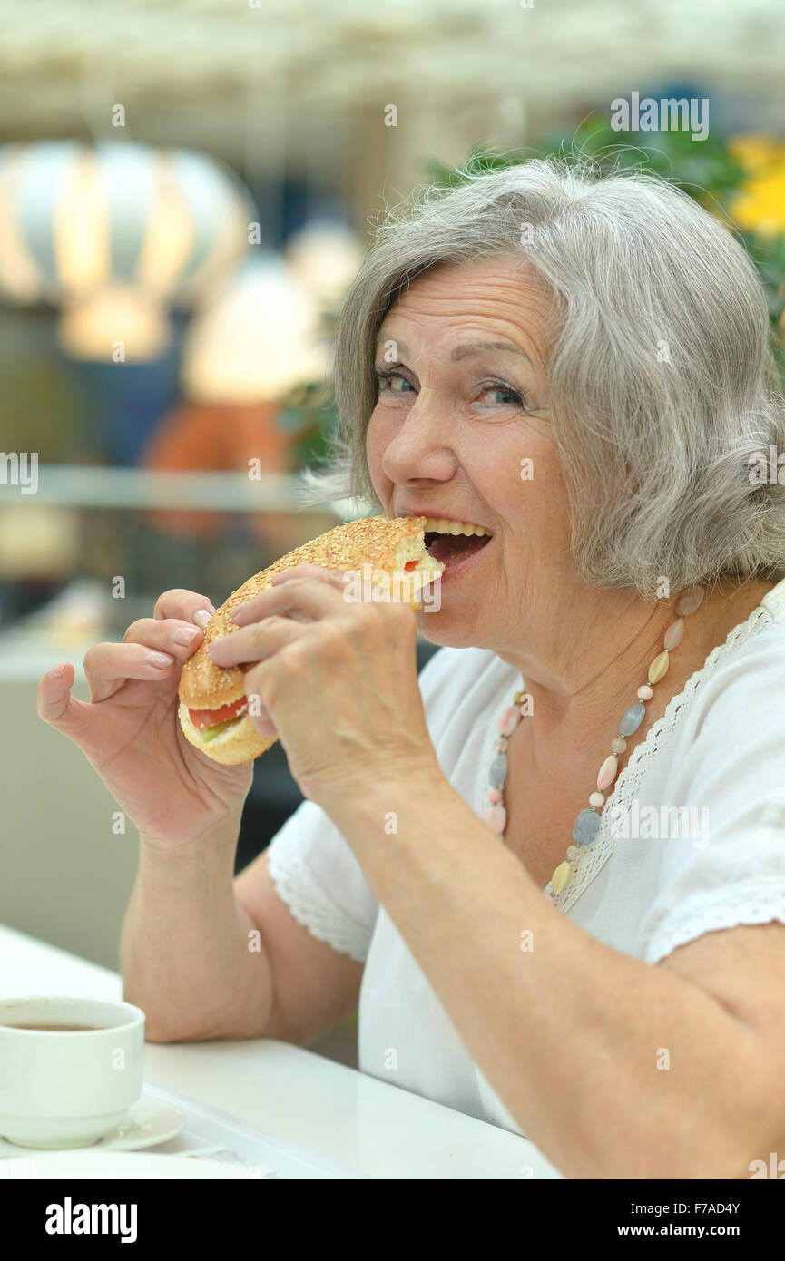 Donna di mangiare hamburger Foto Stock