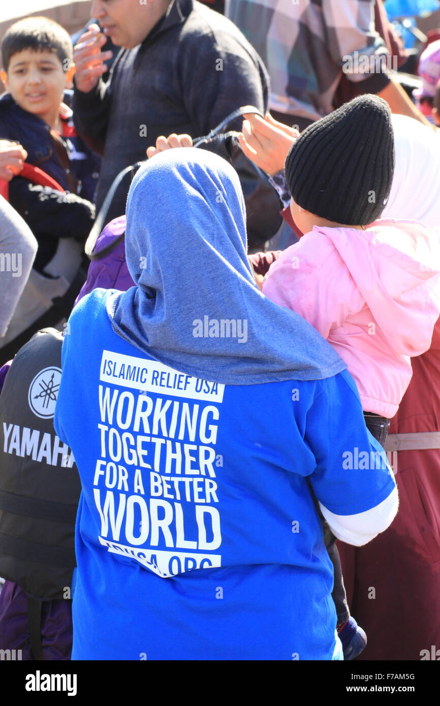 Lavoratori di aiuto aiutare i rifugiati e le famiglie immigrate in molivos sull'isola di Lesbo Grecia dopo la fuga lacerato dalla guerra Siria da barca gonfiabile Foto Stock