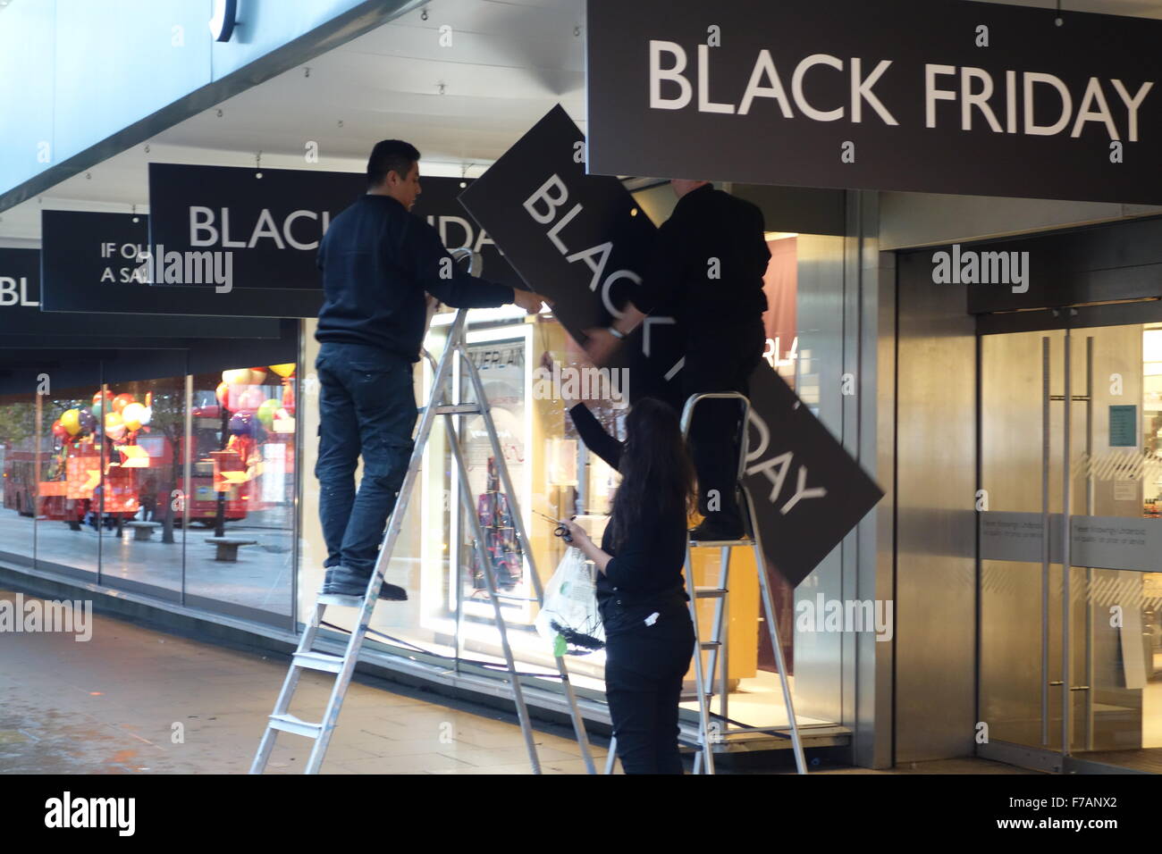 Londra, Regno Unito. 27 Novembre, 2015. Gli installatori messo fino Venerdì nero vendita segni al di fuori John Lewis Store su Oxford Street Credit: CAMimage/Alamy Live News Foto Stock