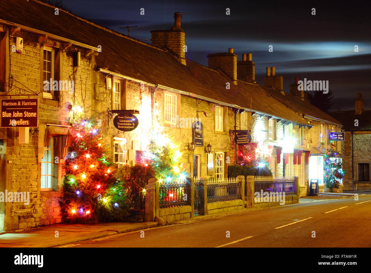 Illuminata di alberi di Natale la linea la strada principale di Castleton; un villaggio nel distretto di Peak, Derbyshire Regno Unito Foto Stock