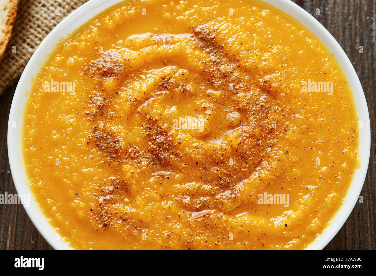 Close-up di zuppa di zucca in bianco ciotola con pane crouton sulla tavola di legno Foto Stock