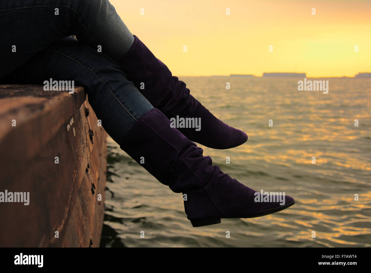 Viola stivali in pelle scamosciata sopra il Mar Caspio al tramonto Foto Stock