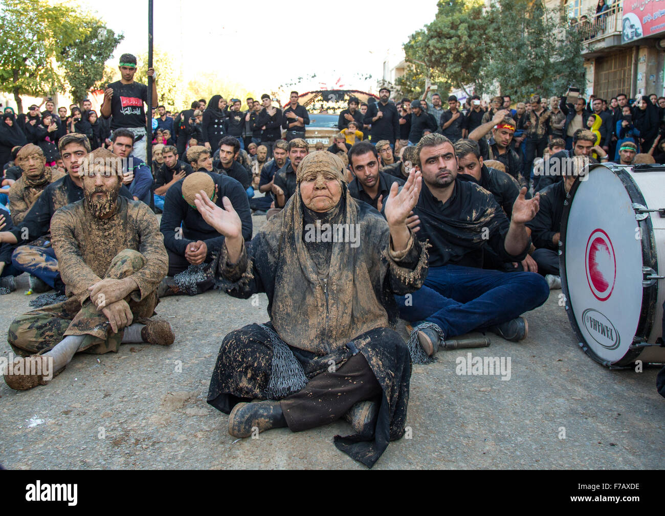 Sciita iraniano donna musulmana coperto di fango pregando nel mezzo di uomini durante il giorno di Ashura, Kurdistan Provincia, Bijar, Iran Foto Stock