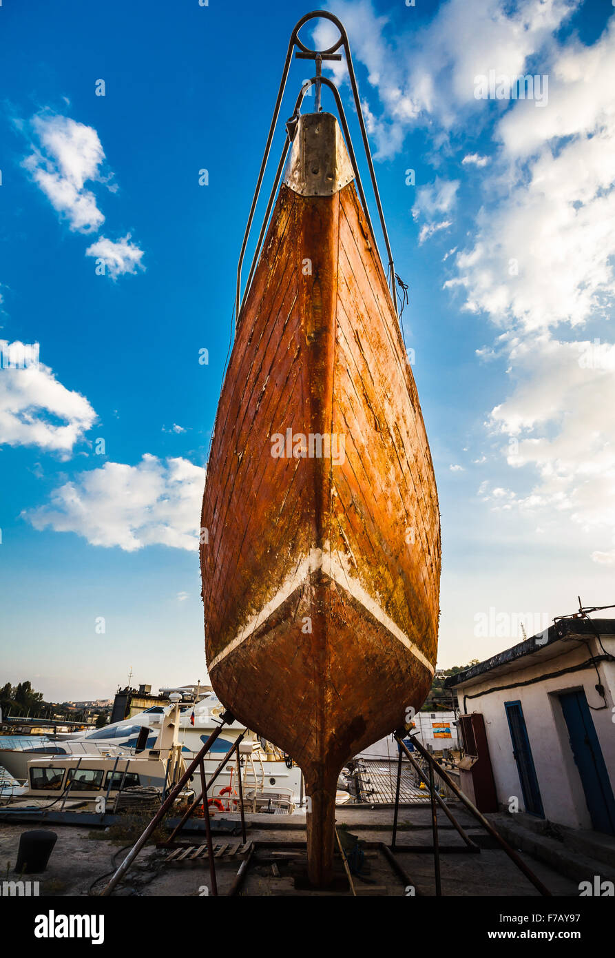 Barca sulla riparazione nel bacino di carenaggio con cielo blu su sfondo Foto Stock