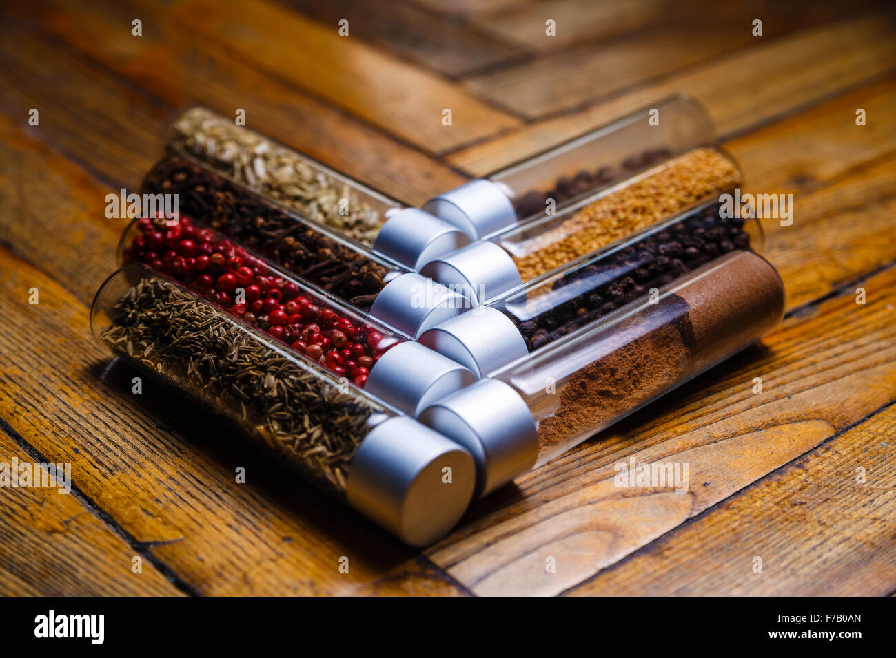 Massa assortiti spezie in bottiglie su sfondo di legno Foto Stock