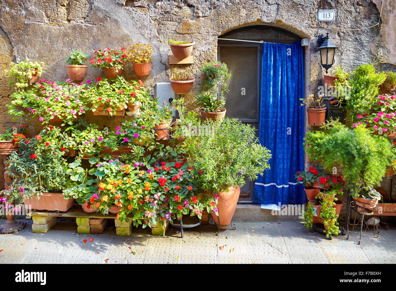 Strada di città decorate con fiori, Pitigliano, Toscana, Italia Foto Stock