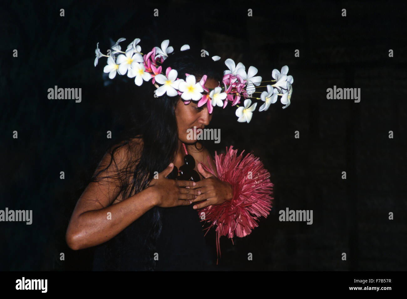 Donna polinesiana che danza hula (hura), che indossa fiori frangipani headdress nel Cook Island Cultural Village Foto Stock