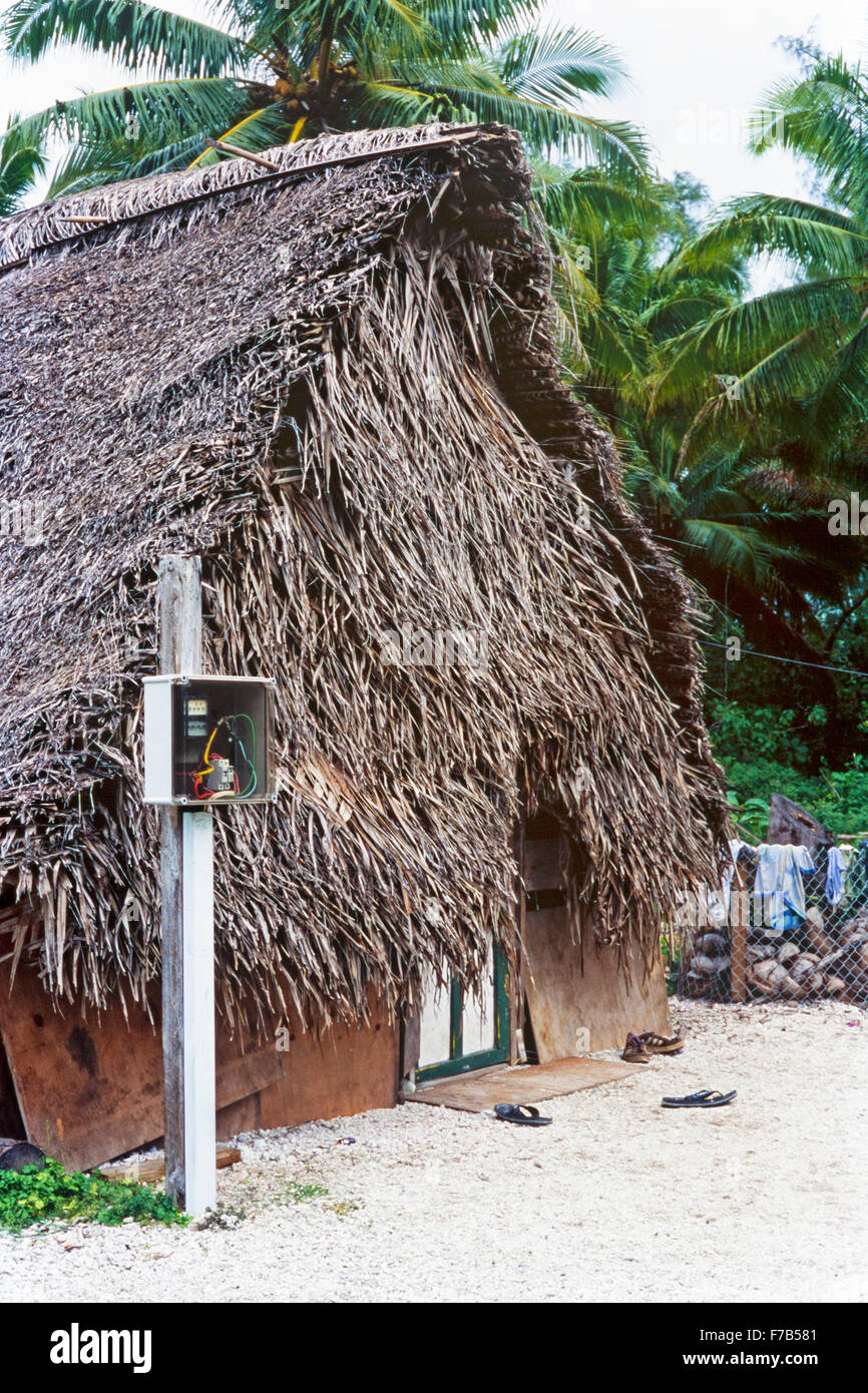Contatore elettrico fuori casa polinesiana con tetto tradizionale di paglia di cocco sull'isola di Mitiaro nelle Isole Cook Foto Stock