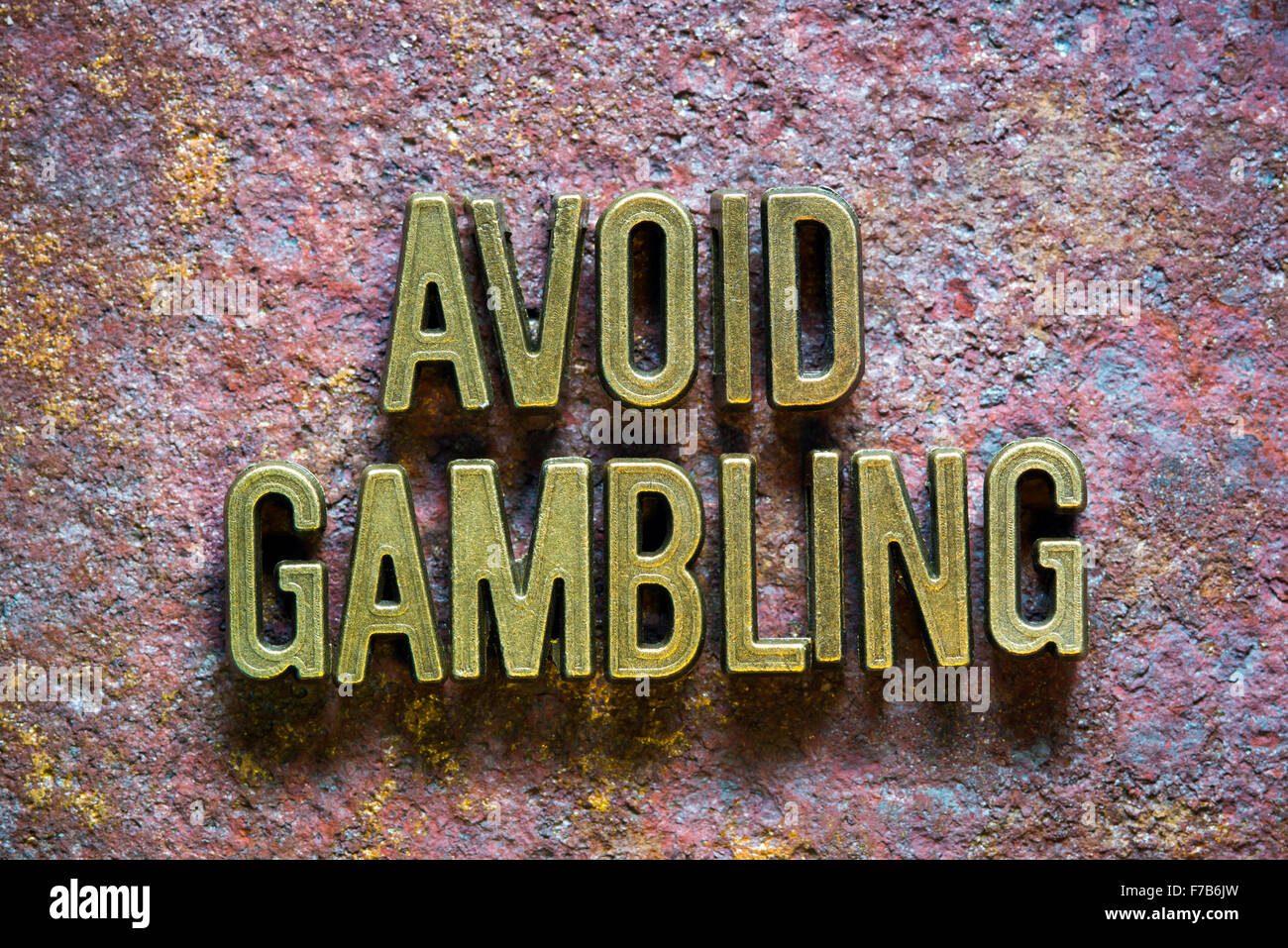 Evitare il gioco d'azzardo frase composta da lettere metalliche su arrugginito sfondo metallico Foto Stock