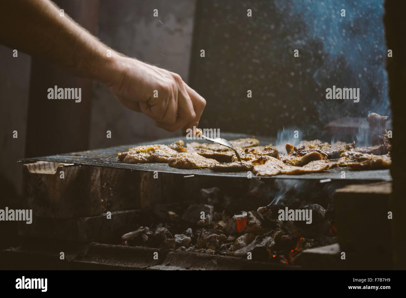Per grigliare carne di maiale braciole sul barbecue, luce naturale, dai toni retrò, messa a fuoco selettiva con profondità di campo ridotta. Foto Stock