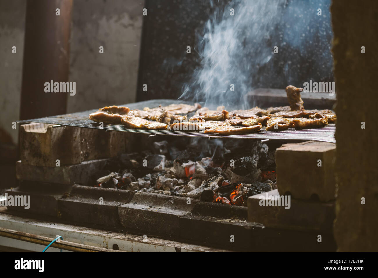 La carne di maiale braciole sul barbecue, luce naturale, dai toni retrò, messa a fuoco selettiva con profondità di campo ridotta. Foto Stock