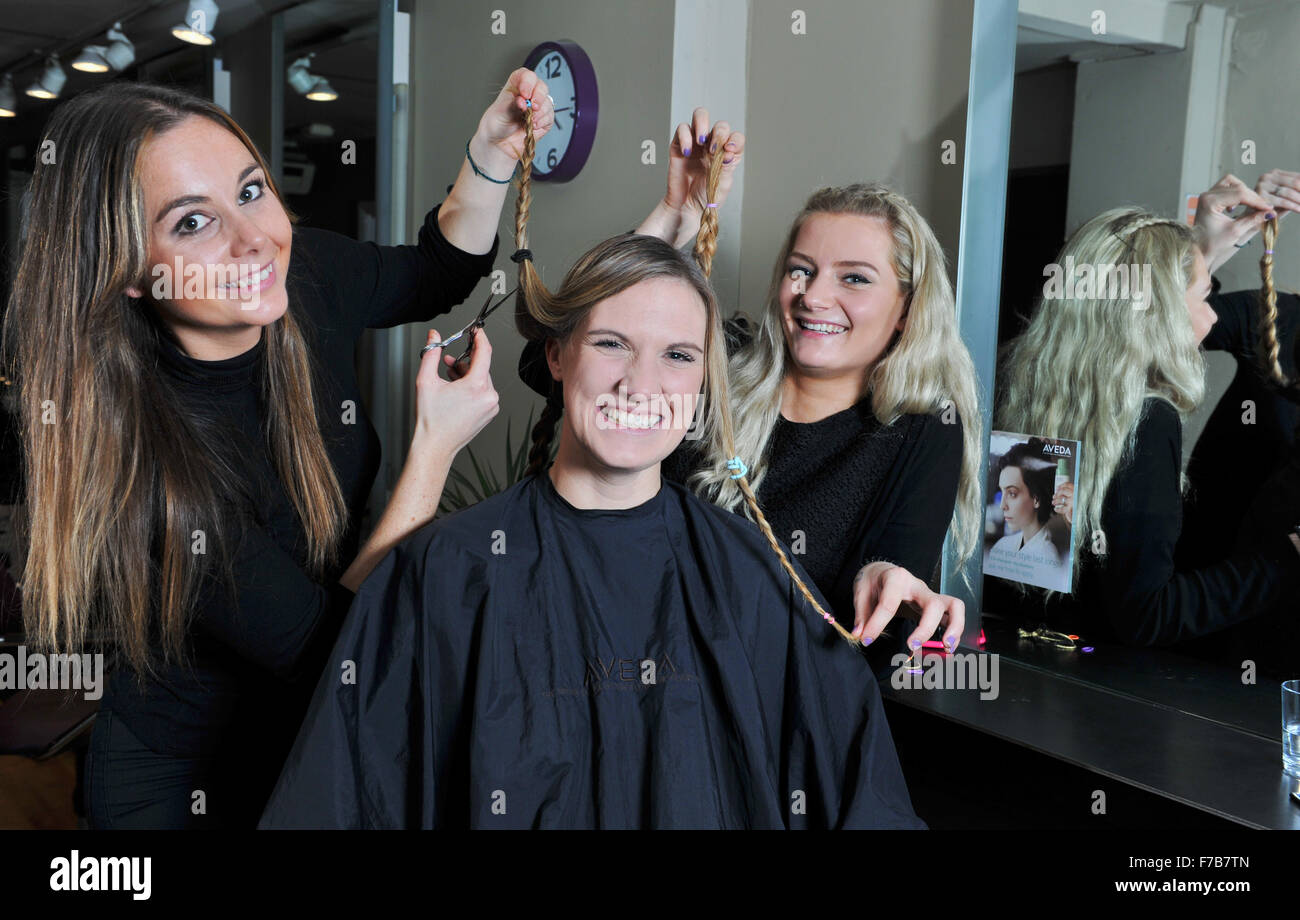 Giovane donna con i capelli tagliati fuori per carità dai parrucchieri ad un salone a Brighton Regno Unito Foto Stock