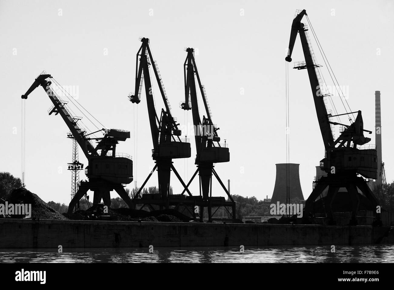 Sagome scure del porto industriale di gru. Fiume Danubio, Bulgaria. Foto in bianco e nero Foto Stock