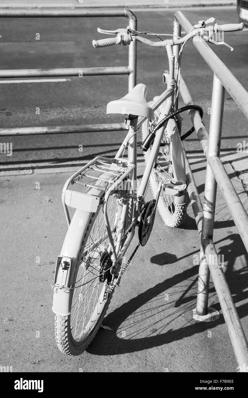 Bianco in stile vecchia bicicletta sorge sul ciglio della strada Foto Stock