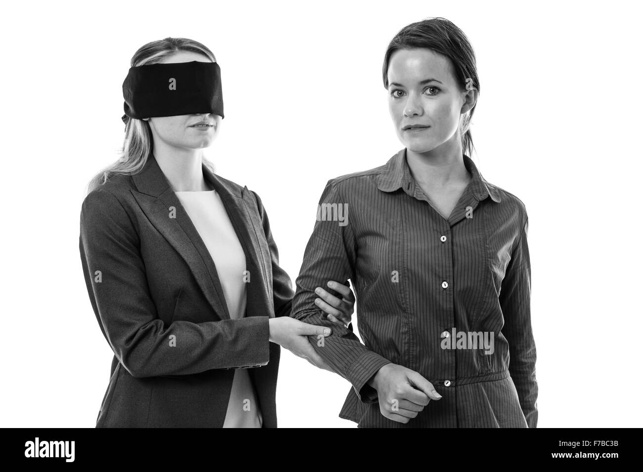 Due business donna uno con gli occhi bendati e gli altri aiutando Foto Stock