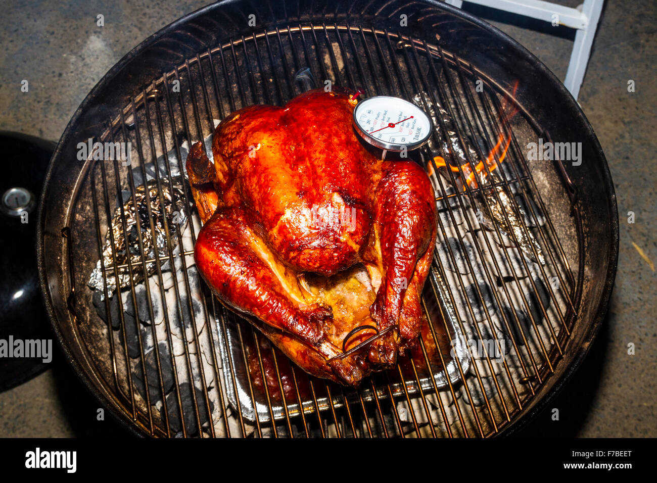 Un sale rub messi in salamoia ringraziamento Turchia cotti su una Weber Kettle barbecue con il termometro della carne che indica se sono cotti Foto Stock