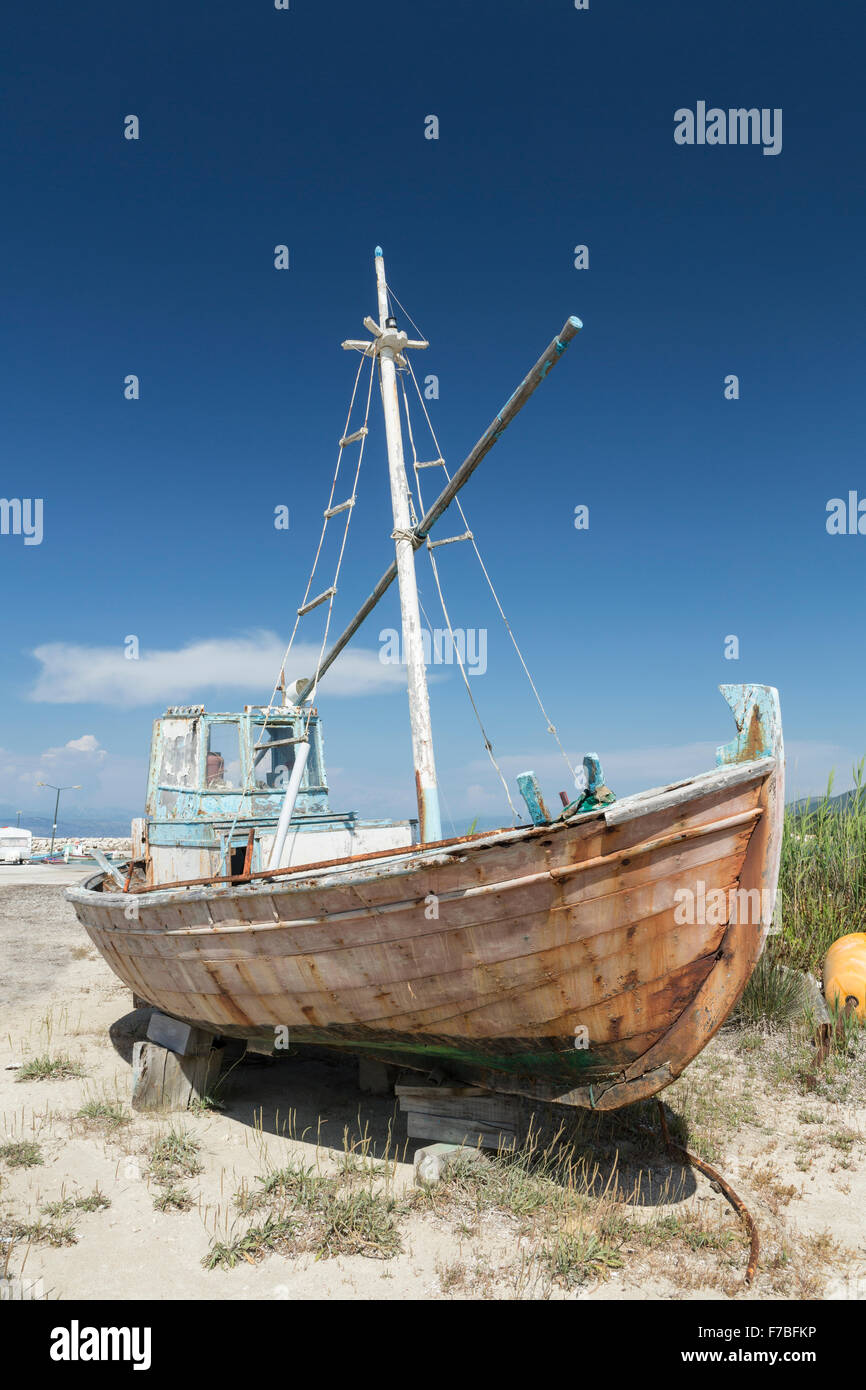 Un vecchio legno greco barca da pesca è di decadimento in un bacino a secco a Astrakeri, Corfù Foto Stock