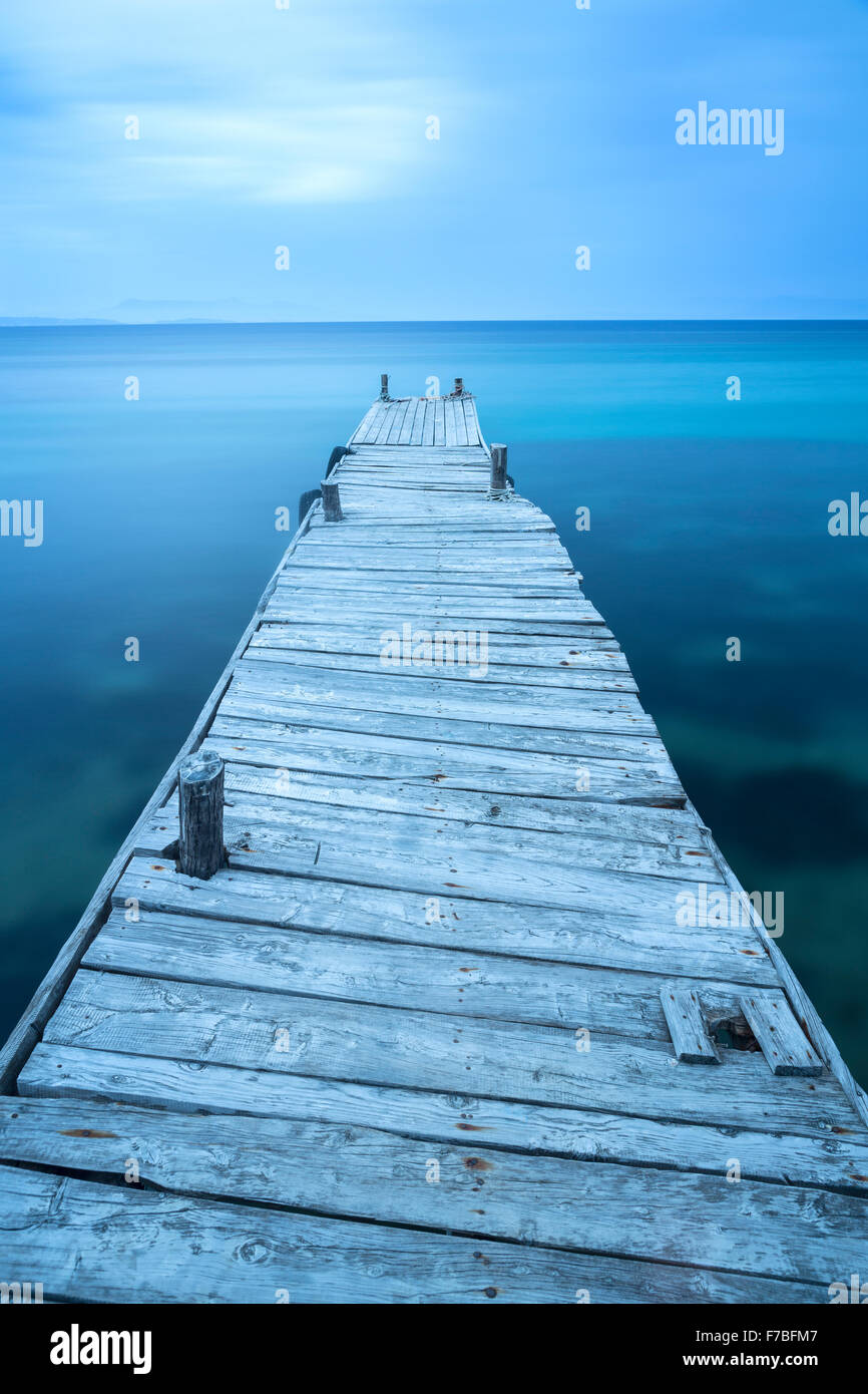 Un vecchio molo in legno si protende nel Mar Ionio a Boukari, Corfù. Foto Stock