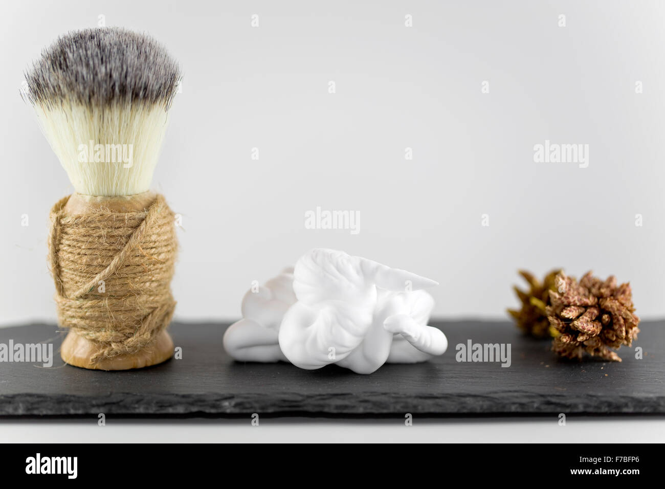 Pennelli per barba e schiuma su sfondo bianco Foto Stock