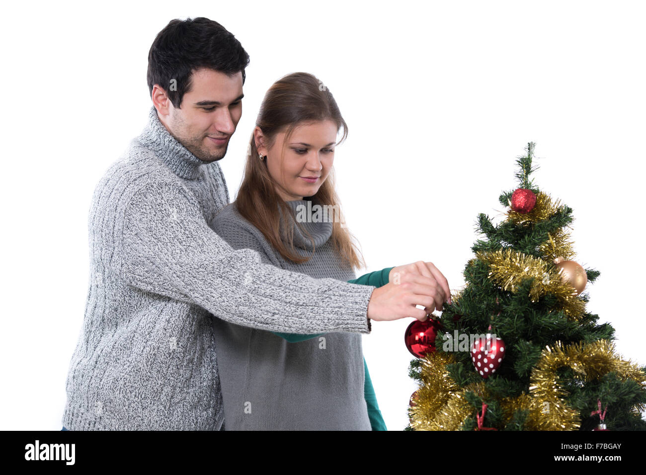 Coppia giovane, uomo e donna, la decorazione albero di natale, sfondo bianco Foto Stock