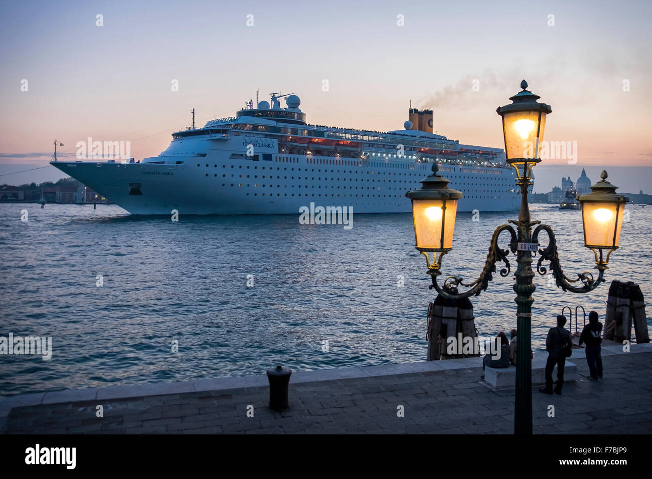 Venezia, Italia, nave da crociera Costa Classica, lasciando al tramonto con i turisti in piedi sulla piattaforma Foto Stock