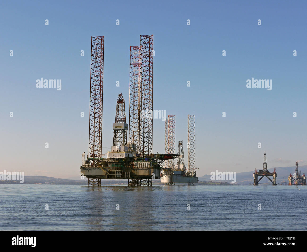 Impianti di trivellazione del petrolio ormeggiati in Cromarty Firth per manutenzione. GSF Monarch Vila in primo piano Foto Stock