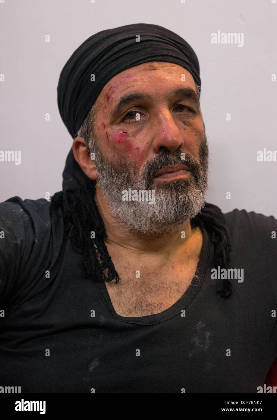 Sciita iraniano Mourner musulmana dal Mad di Hussein comunità con le lesioni sul suo volto causato da auto-flagellazione, Provincia di Isfahan, Kashan, Iran Foto Stock
