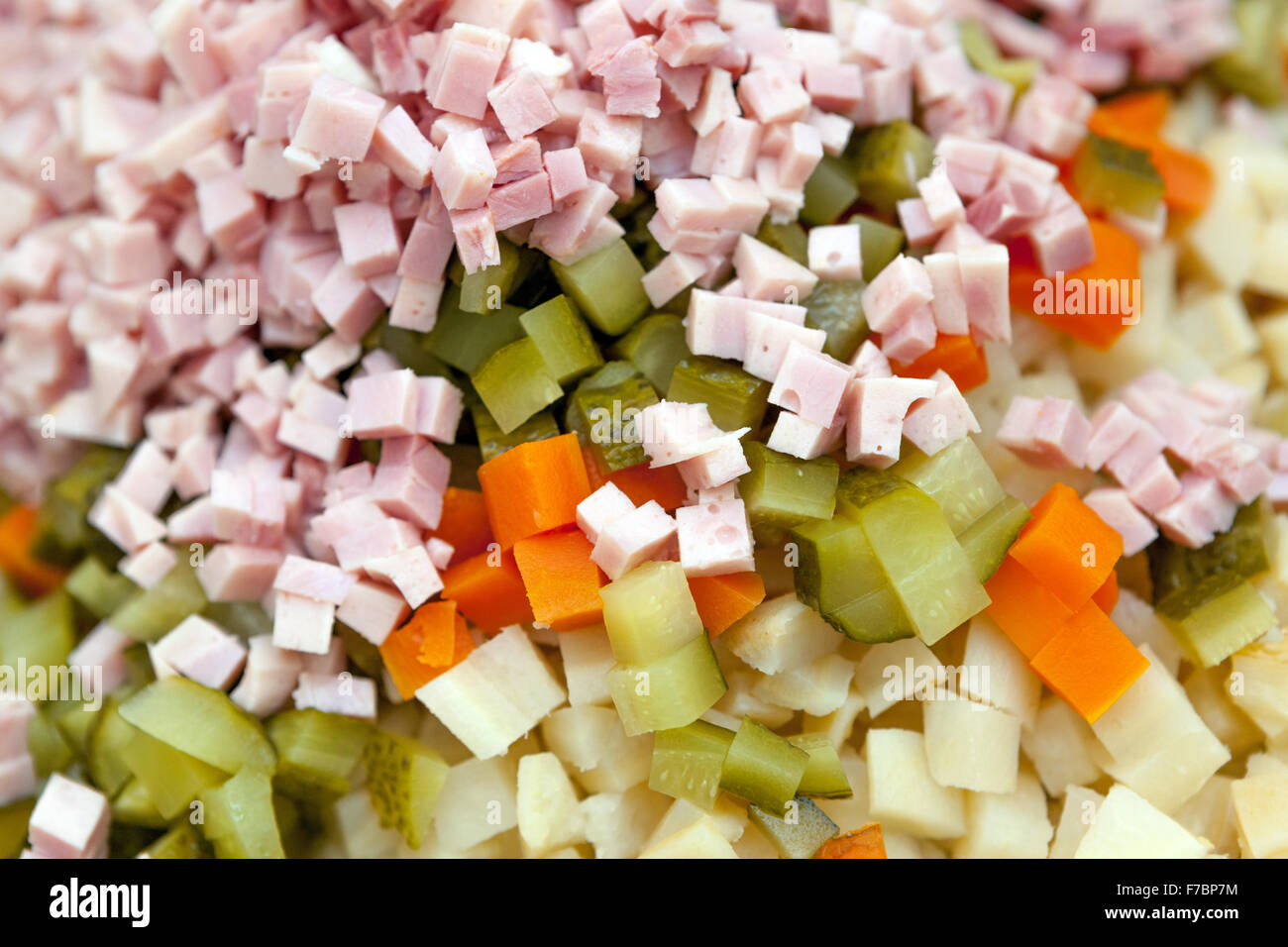 Gli ingredienti in insalata di patate a dadini, salsiccia, cetrioli, carote, patate Foto Stock