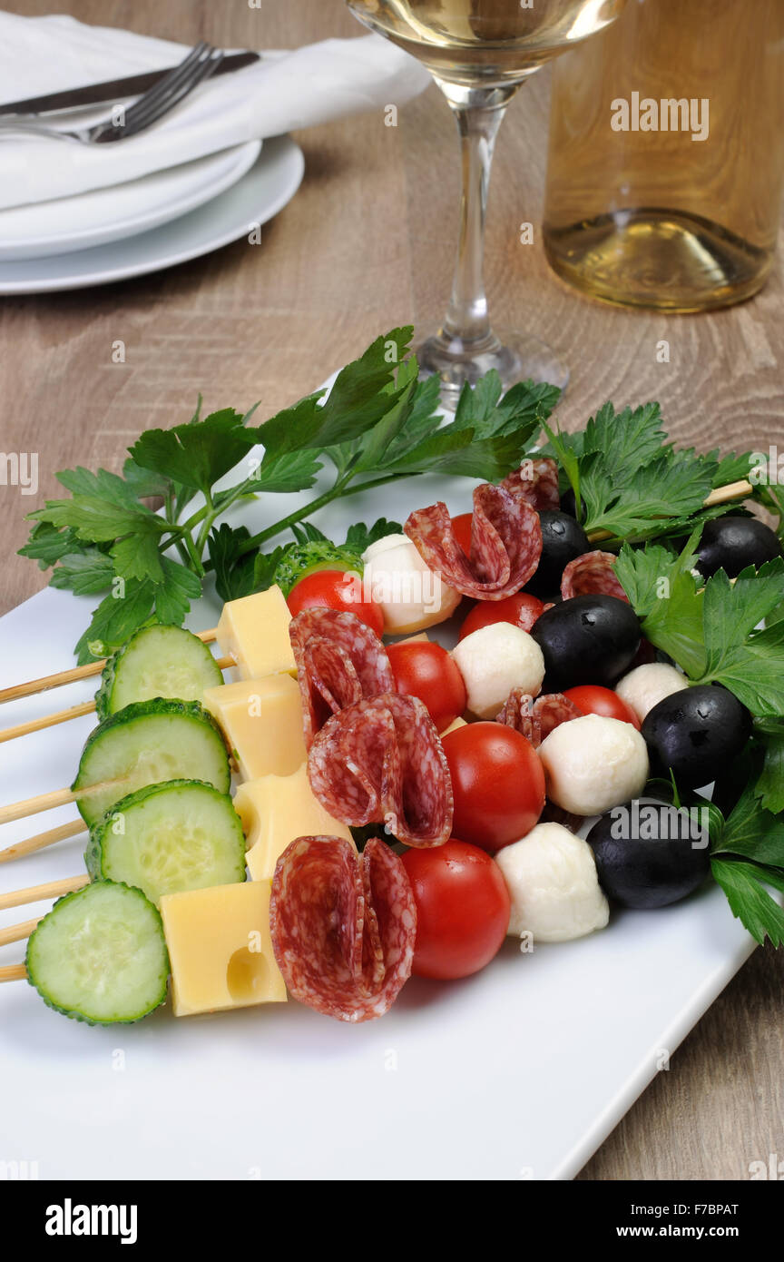 Antipasto di salame con mozzarella, olive, pomodori ciliegini, cetriolo e formaggio su uno spiedino Foto Stock