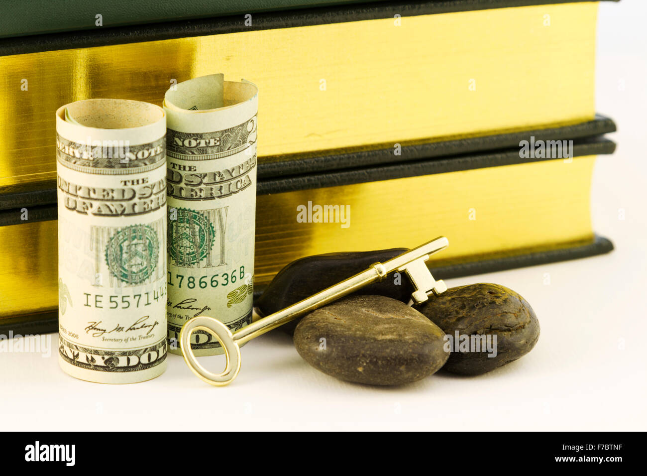 Moneta americana con libri, chiave e rocce simboleggia l'investimento strategico obiettivo di denaro per l'istruzione. Foto Stock