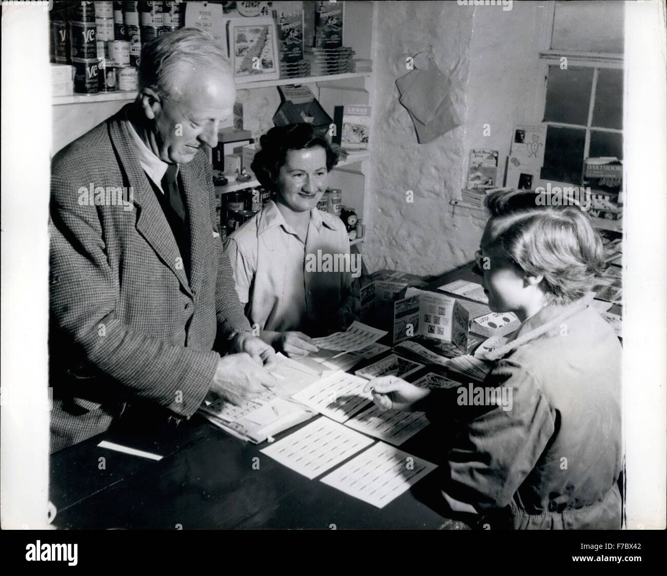 1952 - Lundy Island: in un angolo del Marisco taverna è l'isola del negozio e il sig.F.w.Gade, isola di agente, aiuta a Maria Ogilvy, moglie dell'azienda ufficiale giudiziario per servire i clienti. Sparse sul contatore sono il famoso puffin francobolli usati per la posta in entrata e in uscita e utilizzato per la prima volta nel 1929. © Keystone Pictures USA/ZUMAPRESS.com/Alamy Live News Foto Stock