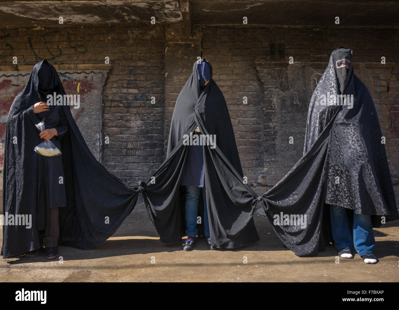 Sciita iraniano donne lutto Hussein su Tasua giornata con le loro facce coperte e i loro vestiti legati come essi non devono parlare, Lorestan Provincia, Khorramabad, Iran Foto Stock