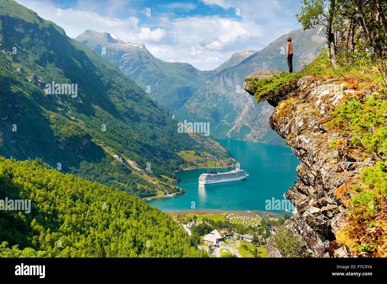 Tourist permanente sulla roccia, la nave di crociera nel Fiordo di Geiranger in background, Norvegia Foto Stock