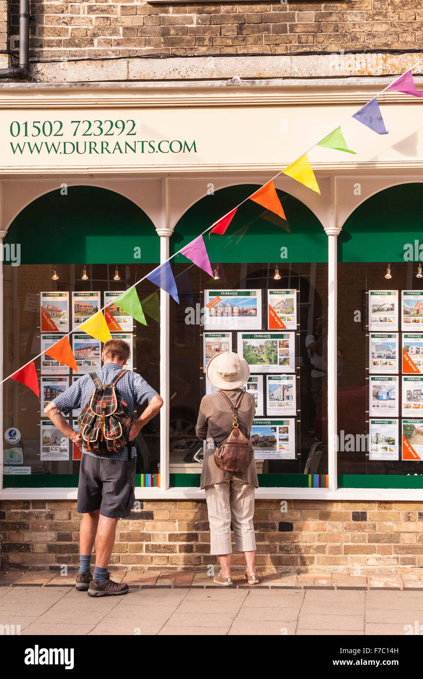 Le persone che cercano in Durrants agente immobiliare nella finestra Southwold , Suffolk , Inghilterra , Inghilterra , Regno Unito Foto Stock