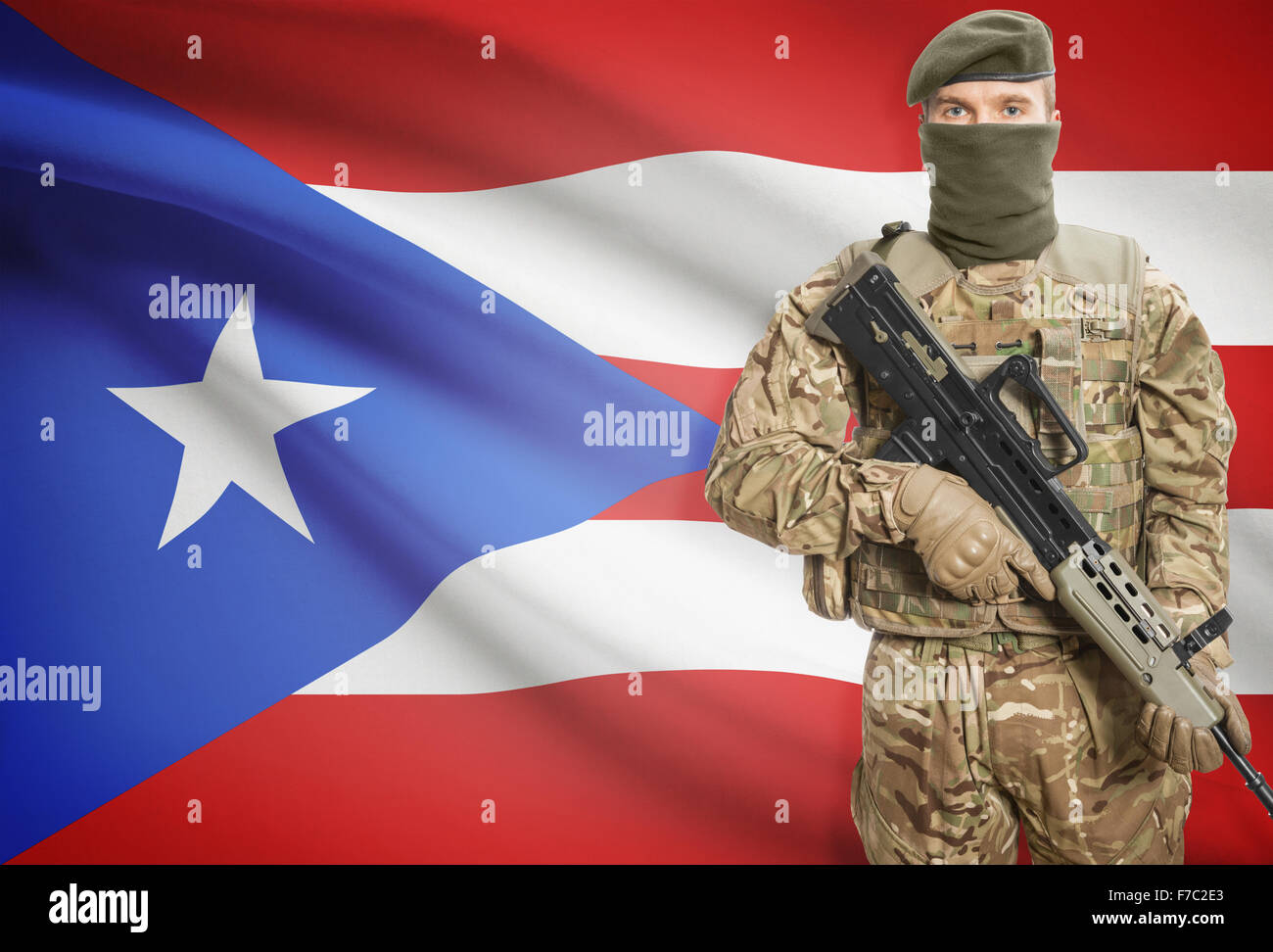 Soldier holding mitragliatrice con bandiera nazionale su sfondo - Puerto Rico Foto Stock